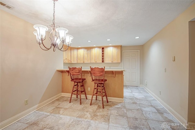 kitchen featuring pendant lighting, light tile patterned floors, kitchen peninsula, and a kitchen breakfast bar