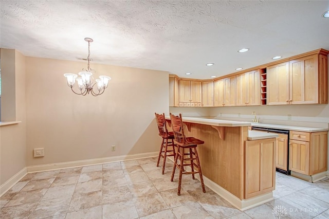 kitchen with a notable chandelier, light tile patterned floors, light brown cabinets, a breakfast bar area, and kitchen peninsula