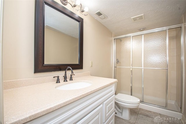 bathroom with vanity, tile patterned floors, a shower with shower door, toilet, and a textured ceiling