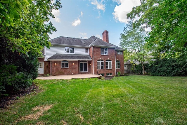 rear view of house with a patio and a lawn