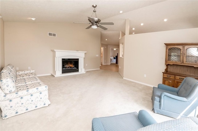 carpeted living room with ceiling fan and lofted ceiling