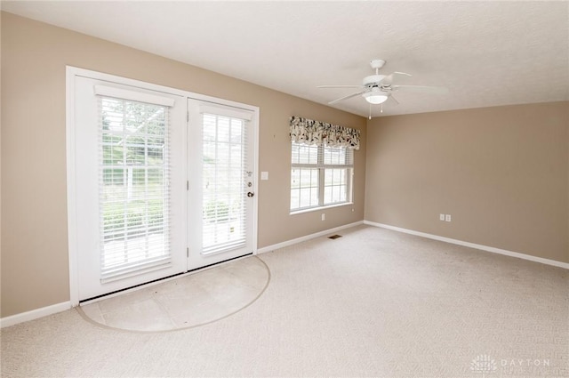 doorway to outside featuring a wealth of natural light, ceiling fan, and light colored carpet