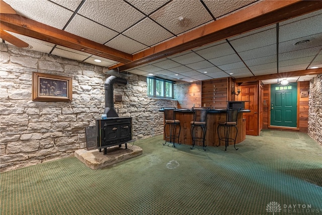 bar with a paneled ceiling and a wood stove