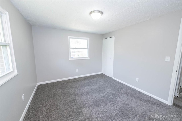 spare room featuring carpet flooring and a textured ceiling