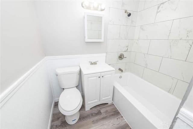 full bathroom with hardwood / wood-style flooring, vanity, toilet, and tiled shower / bath combo