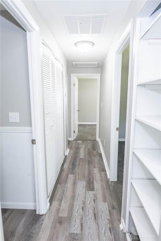 corridor with hardwood / wood-style flooring