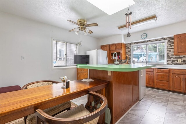 kitchen featuring a textured ceiling, white refrigerator, and ceiling fan