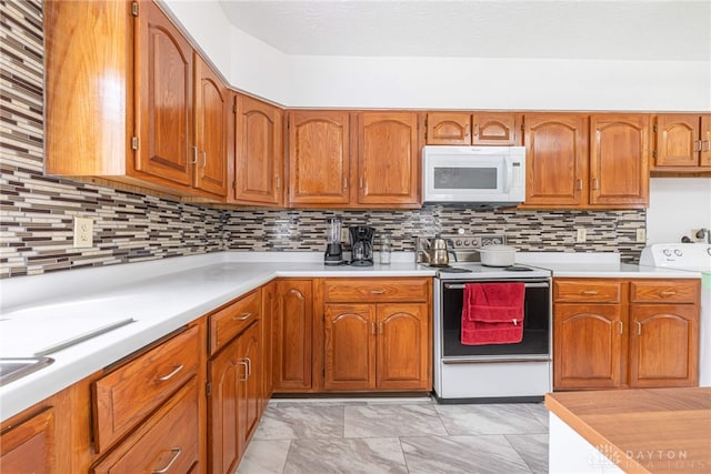 kitchen featuring tasteful backsplash, white appliances, and washer / dryer