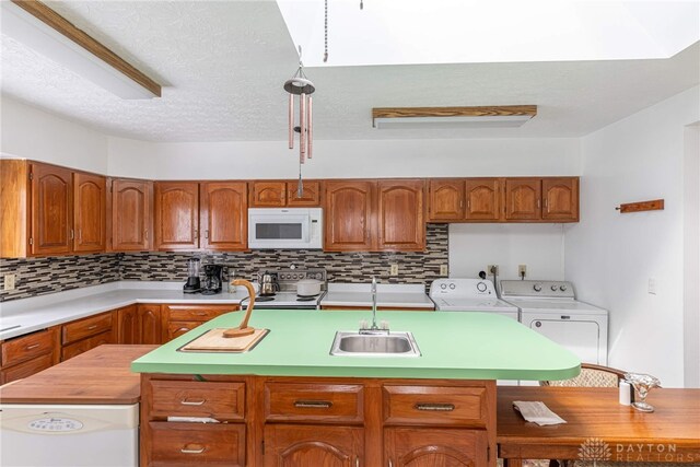 kitchen featuring decorative backsplash, stainless steel electric range oven, a kitchen island, and washing machine and clothes dryer