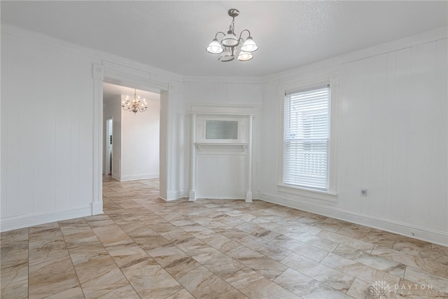 unfurnished dining area featuring a chandelier, a textured ceiling, and ornamental molding