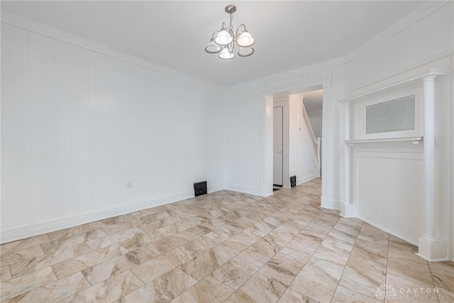 empty room featuring crown molding and a notable chandelier