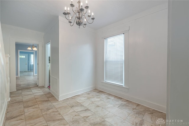 spare room with a chandelier and crown molding