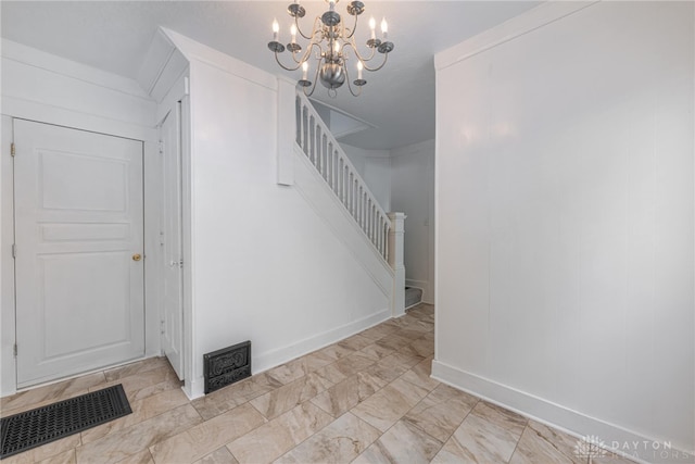 stairs with a notable chandelier