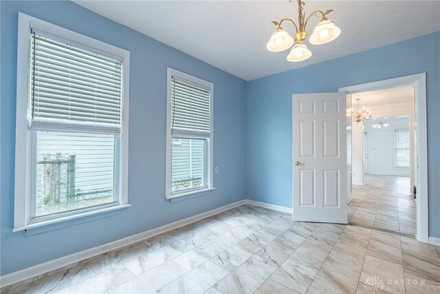 empty room with a chandelier and plenty of natural light