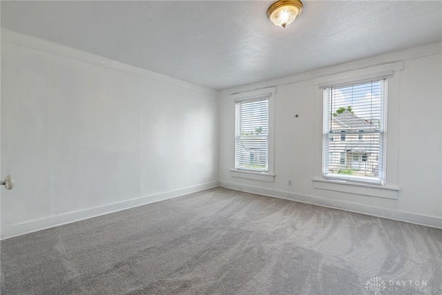 carpeted spare room with a textured ceiling