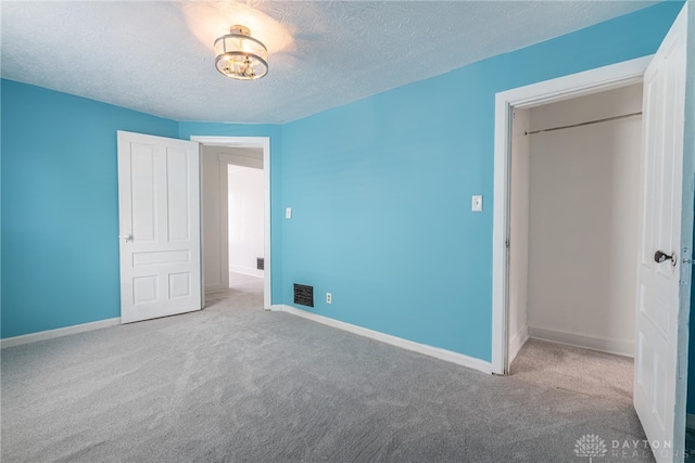 unfurnished bedroom featuring light colored carpet and a textured ceiling