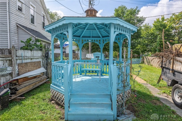 wooden terrace with a gazebo and a lawn