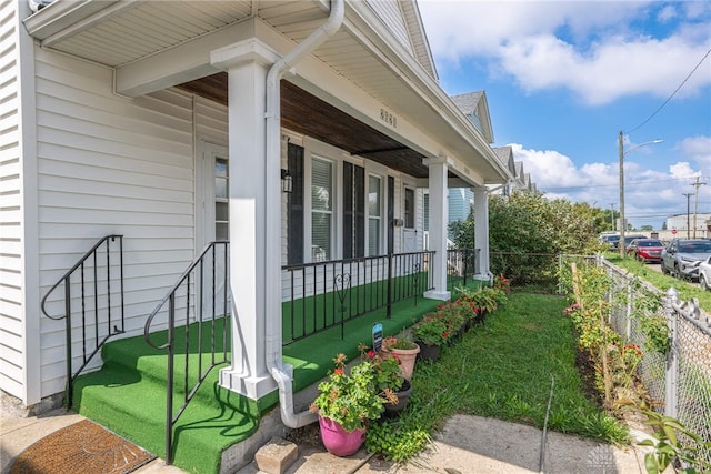 view of side of home featuring covered porch