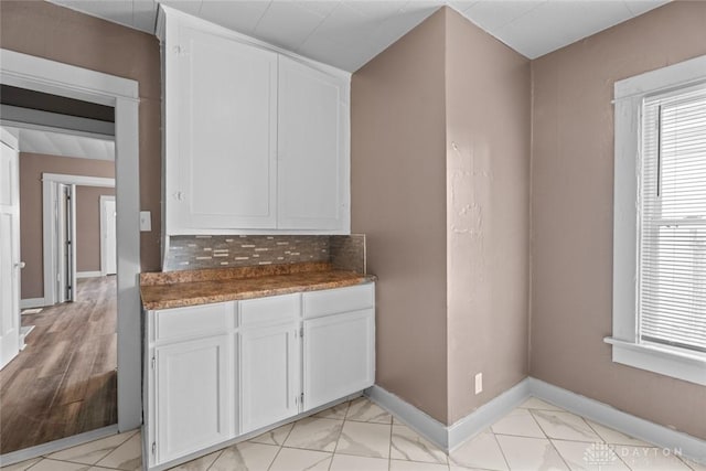 kitchen featuring tasteful backsplash and white cabinets