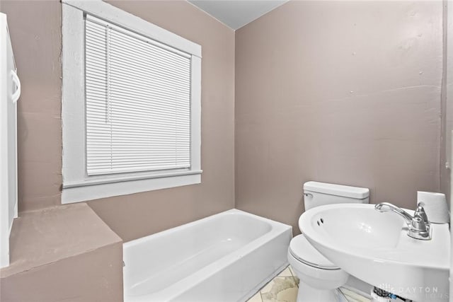 bathroom featuring sink, a bathtub, and toilet