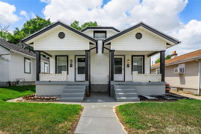 bungalow-style house featuring a front lawn and covered porch