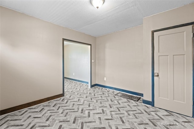 unfurnished room with a textured ceiling