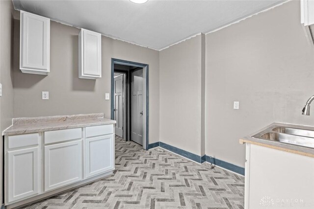 kitchen featuring white cabinetry and sink