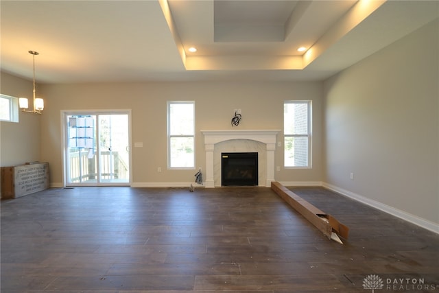 unfurnished living room featuring dark hardwood / wood-style floors and a raised ceiling