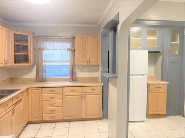 kitchen with crown molding, tasteful backsplash, white refrigerator, and light tile patterned floors