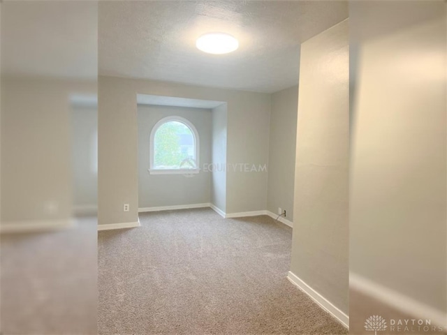 unfurnished room with carpet floors and a textured ceiling