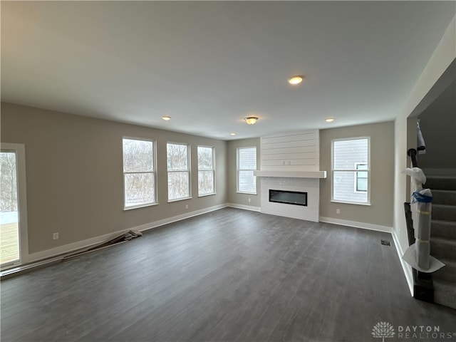 unfurnished living room with dark wood-type flooring