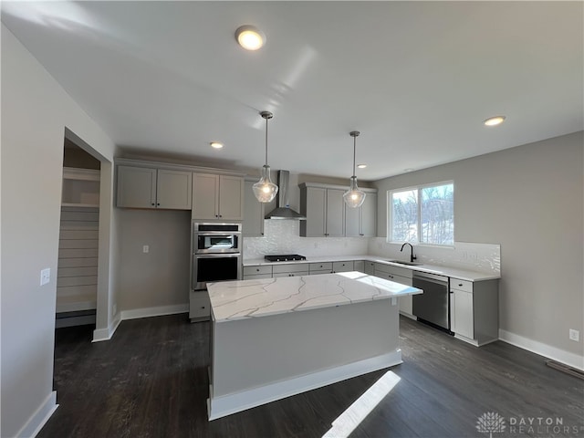 kitchen with gray cabinets, a center island, wall chimney exhaust hood, and appliances with stainless steel finishes