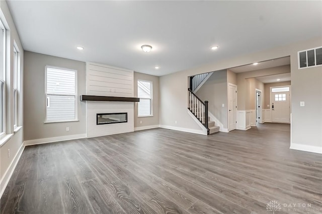 unfurnished living room with dark hardwood / wood-style flooring and a fireplace