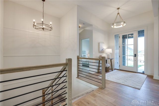 entrance foyer with light hardwood / wood-style floors and an inviting chandelier