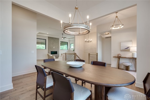 dining area with light hardwood / wood-style flooring and a large fireplace