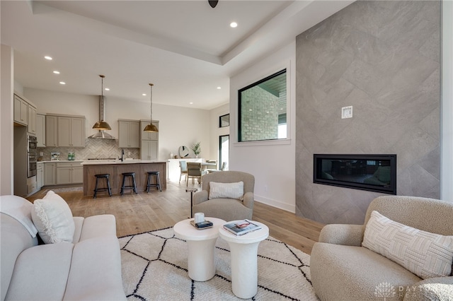 living room with a large fireplace and light wood-type flooring