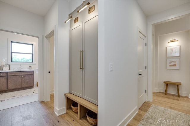 mudroom with light hardwood / wood-style floors and sink