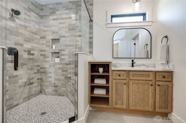 bathroom featuring a shower with door, vanity, and tile patterned flooring