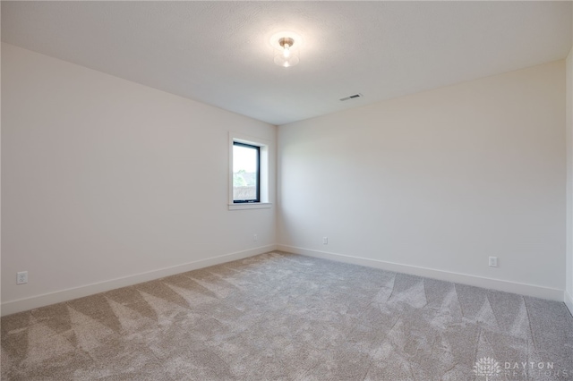 spare room featuring light colored carpet