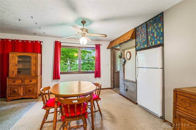 dining area with light carpet, a textured ceiling, and ceiling fan