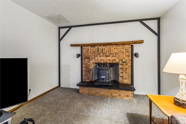 carpeted living room featuring a brick fireplace and a wood stove