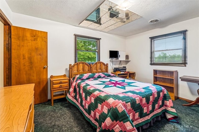 bedroom featuring carpet, visible vents, and a textured ceiling