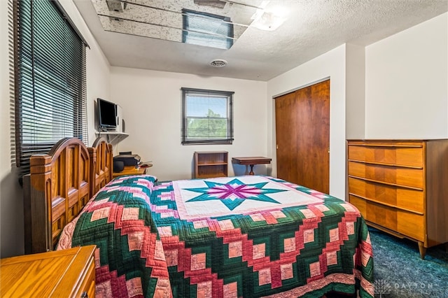 bedroom featuring carpet floors, a textured ceiling, and a closet