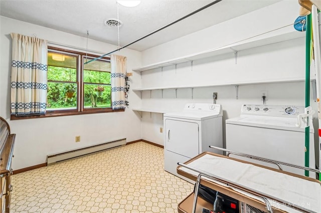 laundry area with a baseboard radiator, laundry area, washing machine and clothes dryer, and baseboards