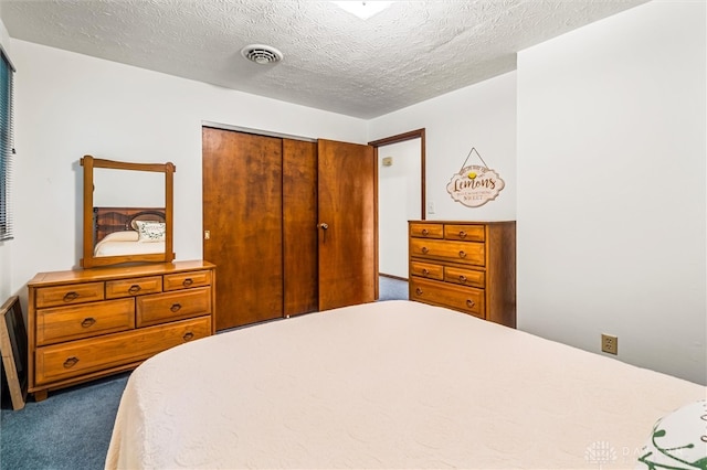 carpeted bedroom with a closet and a textured ceiling