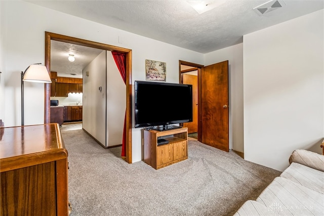 carpeted living room featuring a textured ceiling