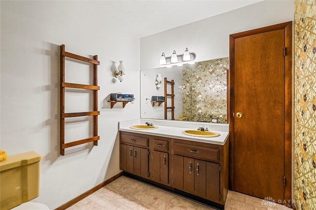 bathroom featuring dual vanity, toilet, and tile patterned floors