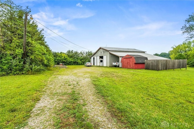 view of yard featuring a barn, driveway, and an outbuilding