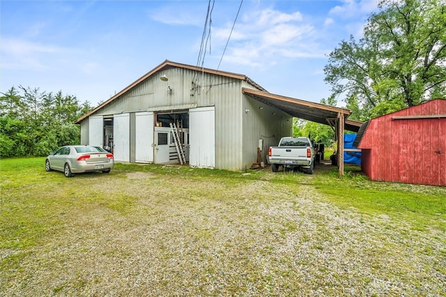 view of outdoor structure featuring a carport and a lawn