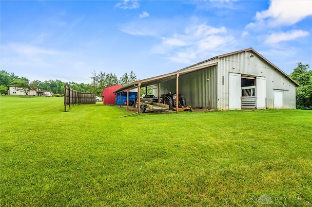 back of house featuring an outbuilding and a lawn